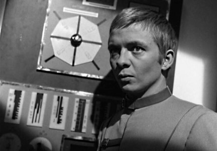 Intense young man standing next to computer panel